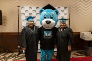 Lisa Smallboy and MaKami Max mascot with her sister Andrea at her graduation from MaKami College's Health Care Aide program