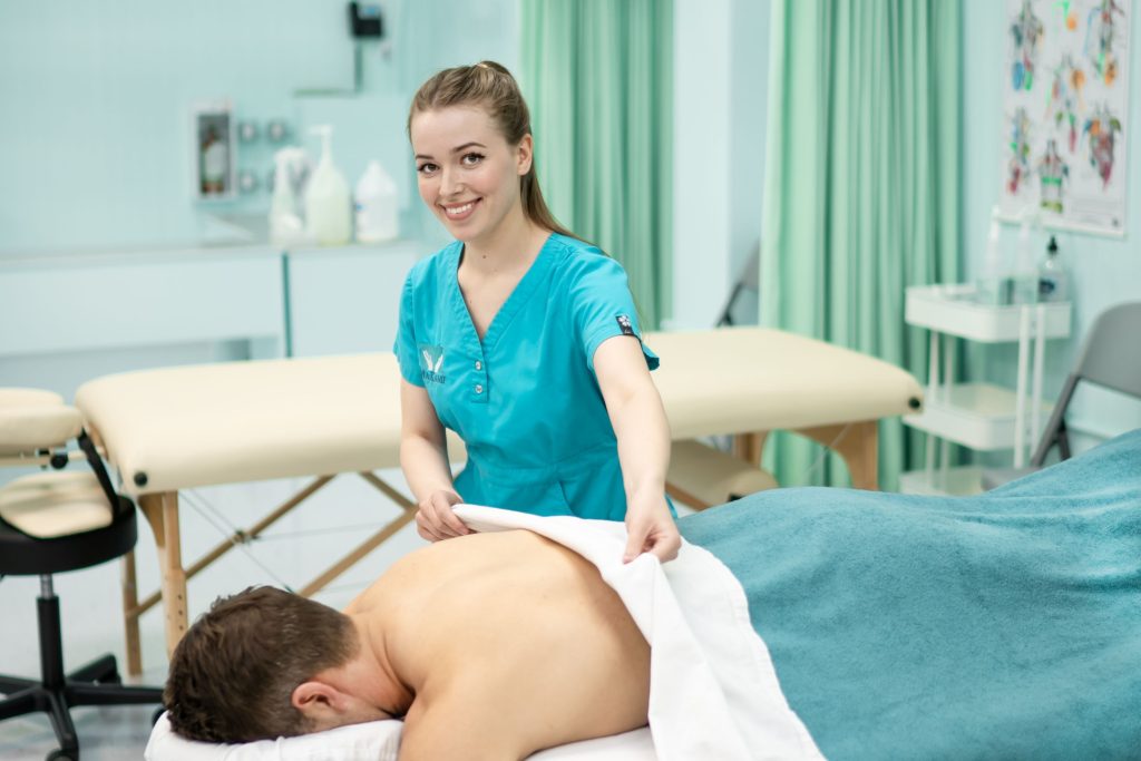 A young, caucasian female massage therapy student massages a client in MaKami College in Calgary, Alberta.